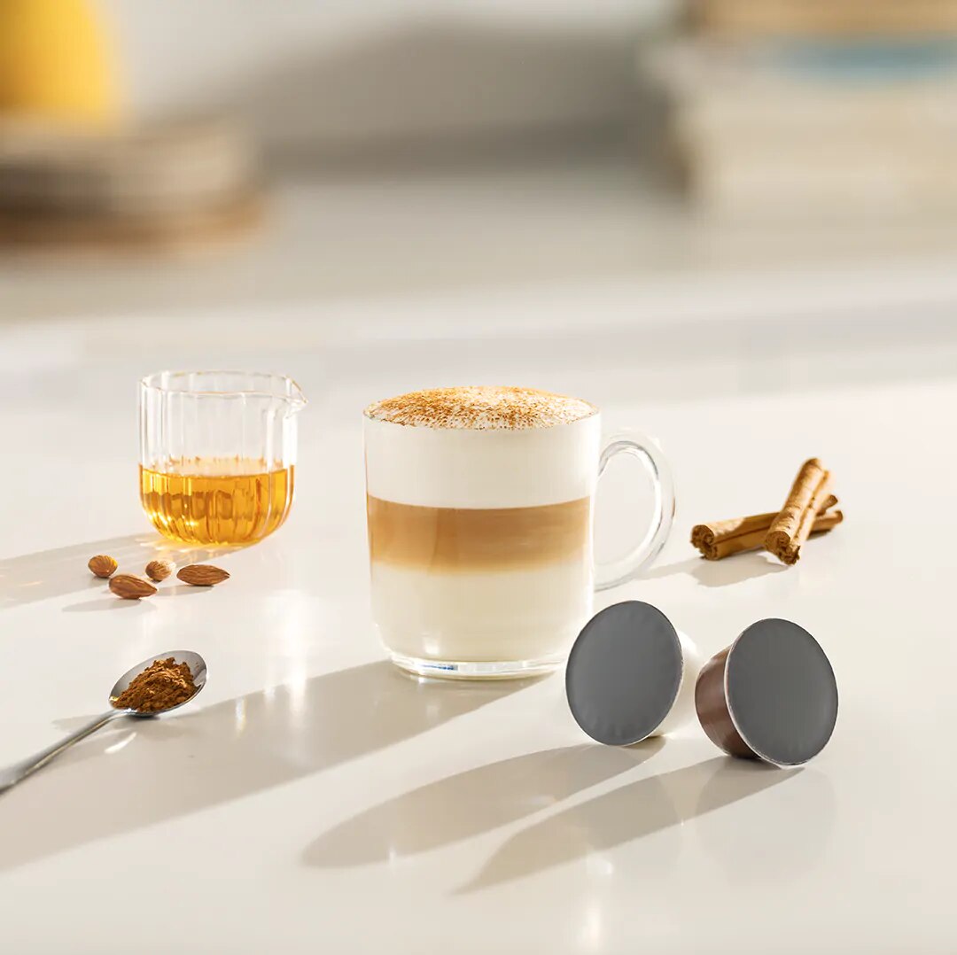 iced cappuccino next to a coffee capsule